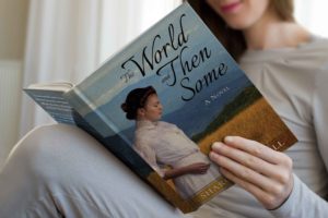 Woman reading "The World and Then Some" by Sharon Randall